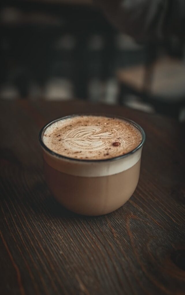 Mastering the First Impression: Your intriguing post title goes here A rich cappuccino with foam art served in a rustic mug on a wooden table, perfect for coffee lovers.